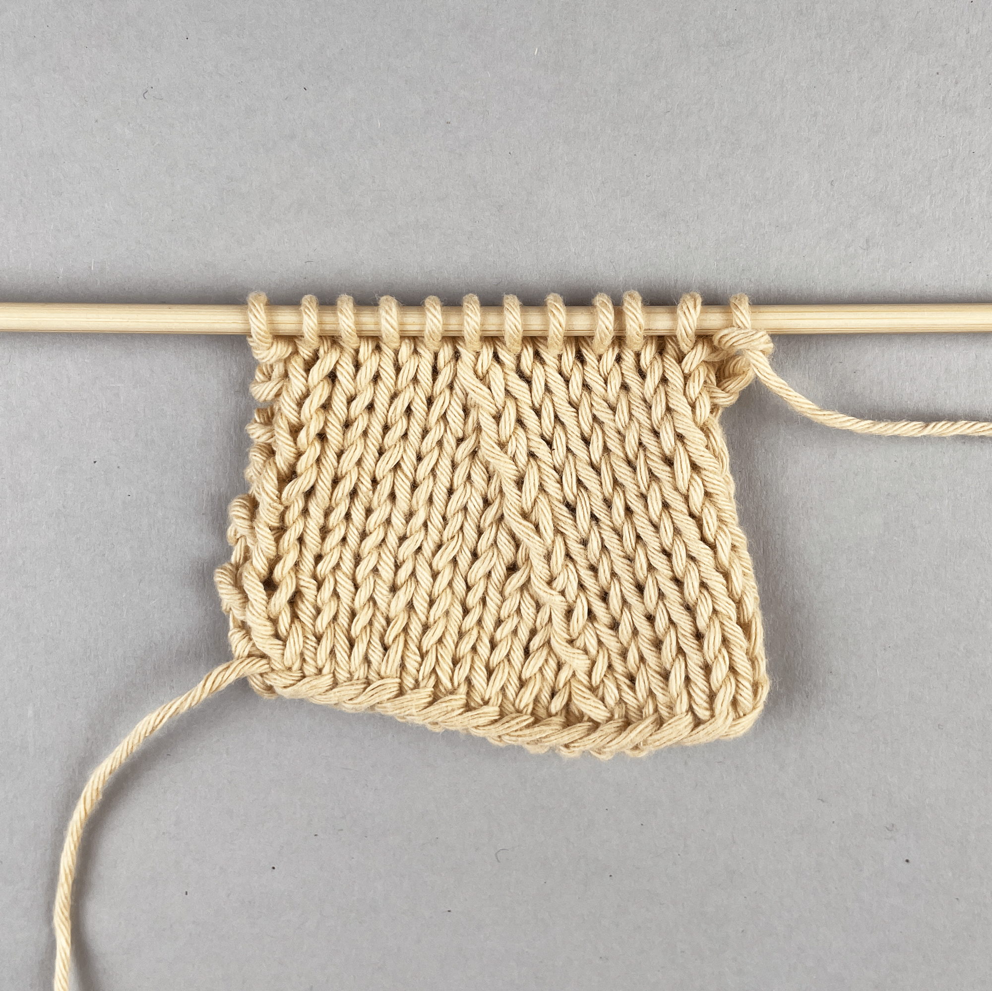 Zwei Maschen überzogen zusammengestrickt